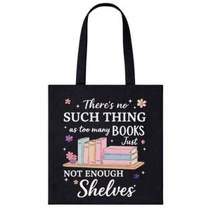 Puede incluir: Bolso tote negro con la cita "No hay demasiados libros, solo no hay suficientes estanter&iacute;as". El dise&ntilde;o incluye una estanter&iacute;a con libros coloridos y detalles florales. El bolso tiene asas negras.