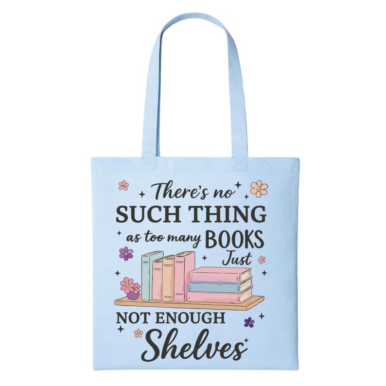 Puede incluir: Bolso tote azul claro con el texto "No hay demasiados libros, solo no hay suficientes estanter&iacute;as". El bolso presenta una imagen de libros en una estanter&iacute;a, con detalles florales.