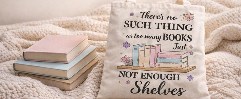 Puede incluir: Un bolso de mano de lona crema con el texto "There's no such thing as too many books, just not enough shelves". El bolso presenta un gr&aacute;fico de libros en una estanter&iacute;a. Tres libros est&aacute;n apilados a la izquierda.