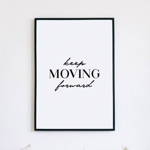 Könnte beinhalten: Ein schwarzer gerahmter Druck mit dem Text "keep MOVING forward" in weißen Buchstaben auf weißem Hintergrund.
