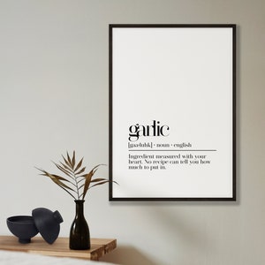 May include: Black and white printable wall art with a minimalist design featuring the word "garlic" and its definition. The text reads: "garlic [gaa-luhk] noun english Ingredient measured with your heart. No recipe can tell you how much to put in."
