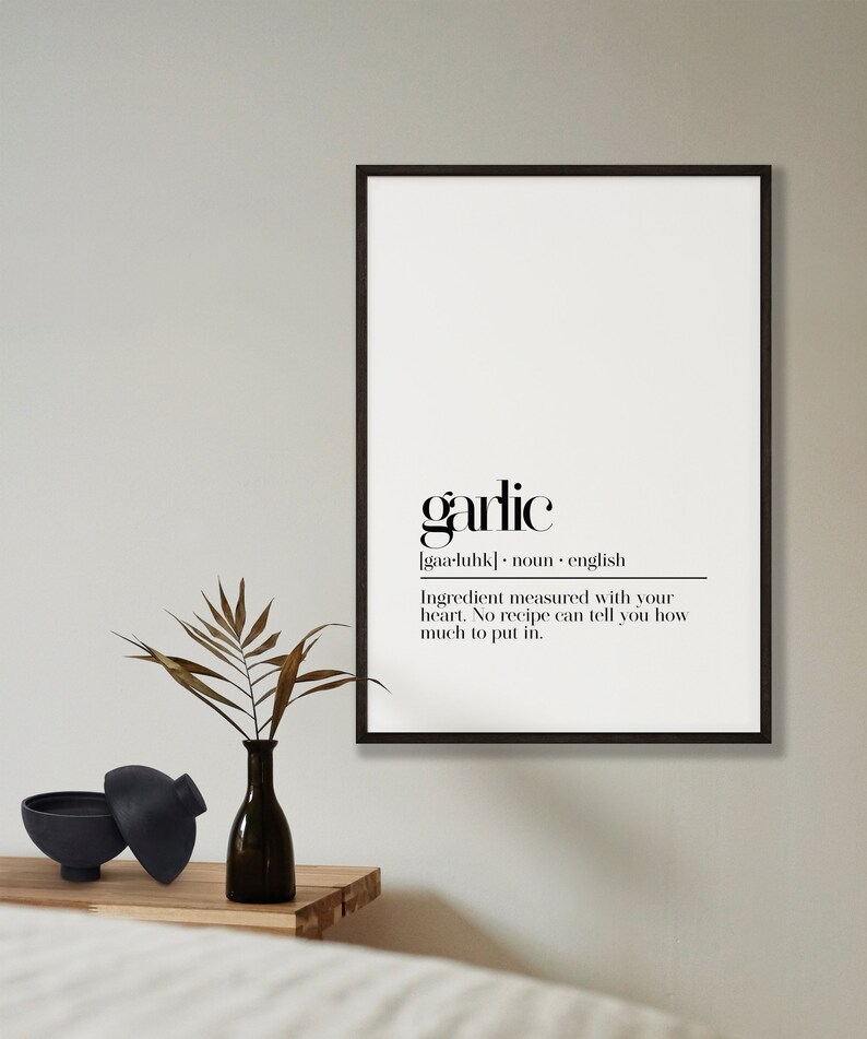 May include: Black and white printable wall art with a minimalist design featuring the word "garlic" and its definition. The text reads: "garlic [gaa-luhk] noun english Ingredient measured with your heart. No recipe can tell you how much to put in."