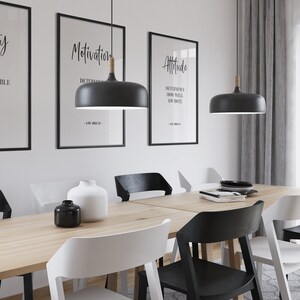 May include: A dining room table with six chairs, two black pendant lights with wooden accents, and three framed motivational quotes on the wall. The quotes are "Ability is what you're capable of doing", "Motivation is determined", and "Attitude determines how well you do it".