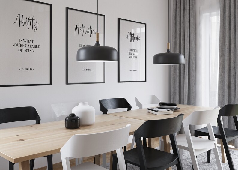 May include: A dining room table with six chairs, two black pendant lights with wooden accents, and three framed motivational quotes on the wall. The quotes are "Ability is what you're capable of doing", "Motivation is determined", and "Attitude determines how well you do it".