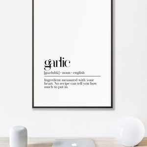 May include: Black and white printable wall art with the word "garlic" defined as an ingredient measured with your heart. The text reads "garlic [gaa-luhk] noun english Ingredient measured with your heart. No recipe can tell you how much to put in."