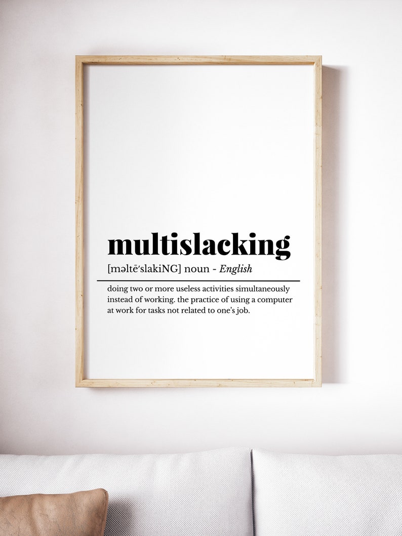 May include: A framed print with a definition of the word "multislacking" in black text on a white background. The definition is: "[məltē'slakiNG] noun - English doing two or more useless activities simultaneously instead of working. the practice of using a computer at work for tasks not related to one's job."