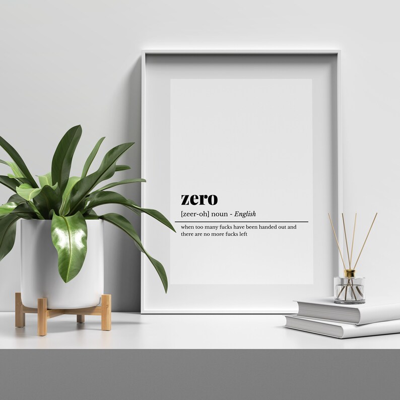 May include: A framed print with the word "zero" in a minimalist design. The definition below reads "when too many fucks have been handed out and there are no more fucks left." A potted plant and books are on the shelf.