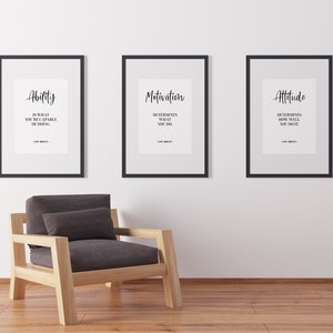 May include: Three black framed motivational posters with white backgrounds and black text. The posters are hung on a white wall. The text on the posters reads "Ability is what you're capable of doing. Motivation determines what you do. Attitude determines how well you do it."