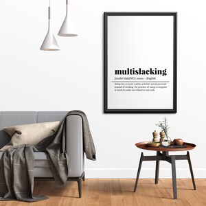 May include: A black framed print with a white background and black text defining the word "multislacking". The definition reads: "[məlt&euml;'slakiNG] noun - English doing two or more useless activities simultaneously instead of working, the practice of using a computer at work for tasks not related to one's job."