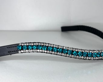 May include: Black headband adorned with rows of teal and clear crystals. The crystals are set in a silver-colored metal, creating a sparkling effect. The headband is made of a black, flexible material.