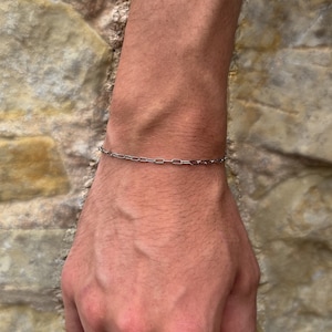 Bracciale unisex con catena sottile in argento e graffetta, braccialetti personalizzati minimalisti da uomo e da donna con catena sottile di Outrage London.