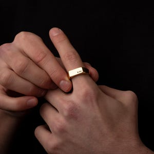 a person holding a gold ring in their hands