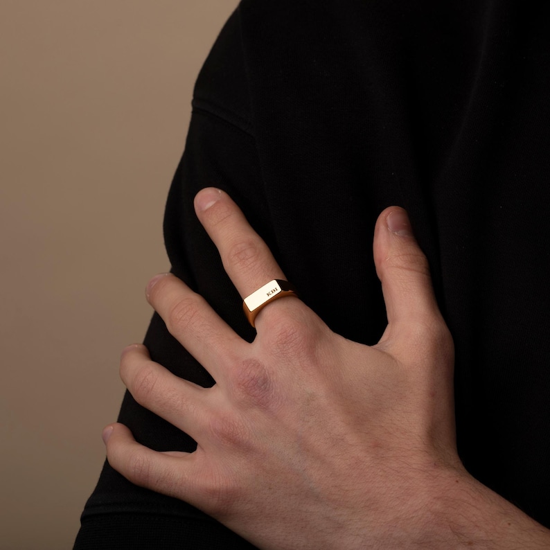 a person wearing a gold ring on their left hand