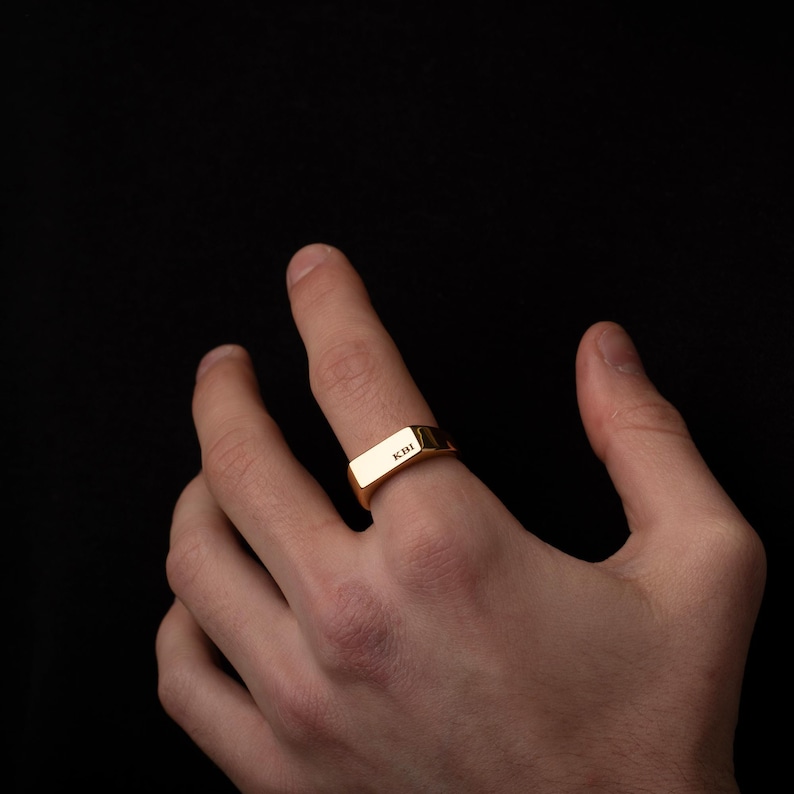 a person's hand with a gold ring on it