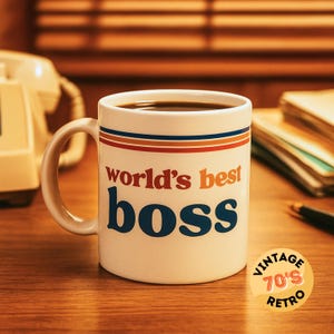 Może przedstawiać: Biały ceramiczny kubek wypełniony kawą, z napisem "world's best boss" w kolorze pomarańczowym i niebieskim. Kubek ma pomarańczowe, czerwone i niebieskie paski przy krawędzi. Na stole znajduje się naklejka w stylu retro z lat 70.
