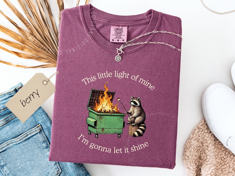 funny dumpster fire shirt, dumpster fire raccoon shirt, raccoon dumpster fire meme tee, trash panda shirt, funny raccoon graphic tee, this little light of mine parody shirt, chaotic raccoon shirt, anxiety humor shirt, funny meme t shirt, roasting marshmallow raccoon tee, comfort colors funny shirt, ironic humor tee, relatable humor shirt, chaos meme shirt, funny animal meme shirt, satirical graphic tee, unhinged raccoon tee, funny gift shirt, mental health meme tee, sarcastic tee, viral shirt