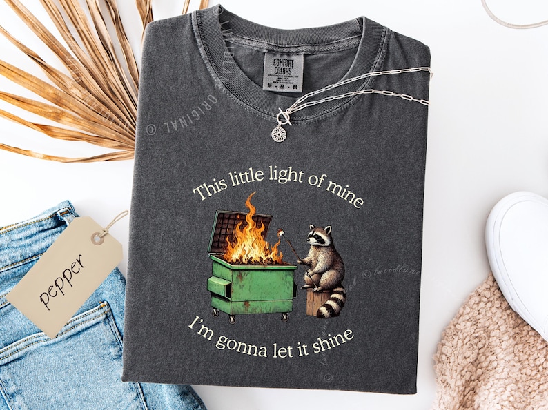 funny dumpster fire shirt, dumpster fire raccoon shirt, raccoon dumpster fire meme tee, trash panda shirt, funny raccoon graphic tee, this little light of mine parody shirt, chaotic raccoon shirt, anxiety humor shirt, funny meme t shirt, roasting marshmallow raccoon tee, comfort colors funny shirt, ironic humor tee, relatable humor shirt, chaos meme shirt, funny animal meme shirt, satirical graphic tee, unhinged raccoon tee, funny gift shirt, mental health meme tee, sarcastic tee, viral shirt