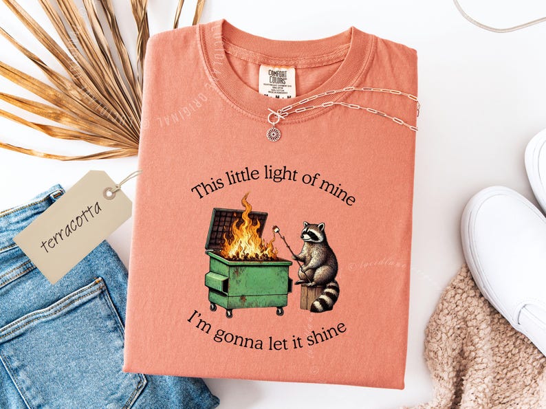 funny dumpster fire shirt, dumpster fire raccoon shirt, raccoon dumpster fire meme tee, trash panda shirt, funny raccoon graphic tee, this little light of mine parody shirt, chaotic raccoon shirt, anxiety humor shirt, funny meme t shirt, roasting marshmallow raccoon tee, comfort colors funny shirt, ironic humor tee, relatable humor shirt, chaos meme shirt, funny animal meme shirt, satirical graphic tee, unhinged raccoon tee, funny gift shirt, mental health meme tee, sarcastic tee, viral shirt