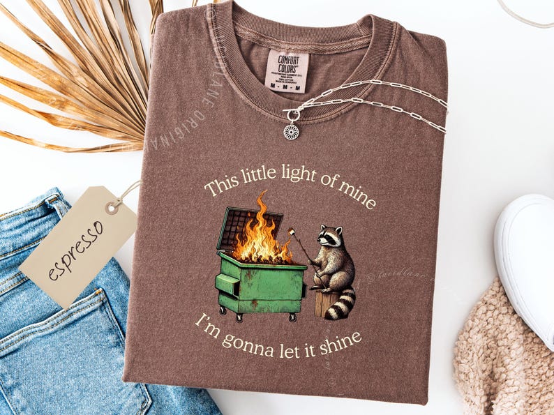 funny dumpster fire shirt, dumpster fire raccoon shirt, raccoon dumpster fire meme tee, trash panda shirt, funny raccoon graphic tee, this little light of mine parody shirt, chaotic raccoon shirt, anxiety humor shirt, funny meme t shirt, roasting marshmallow raccoon tee, comfort colors funny shirt, ironic humor tee, relatable humor shirt, chaos meme shirt, funny animal meme shirt, satirical graphic tee, unhinged raccoon tee, funny gift shirt, mental health meme tee, sarcastic tee, viral shirt