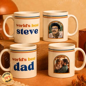 Może przedstawiać: Cztery białe ceramiczne kubki o retro designie. Dwa kubki mają napis "world's best Steve" i "world's best dad" w niebieskim i pomarańczowym tekście. Pozostałe dwa kubki zawierają zdjęcia. Każdy kubek ma niebieski, żółty i czerwony pasek.