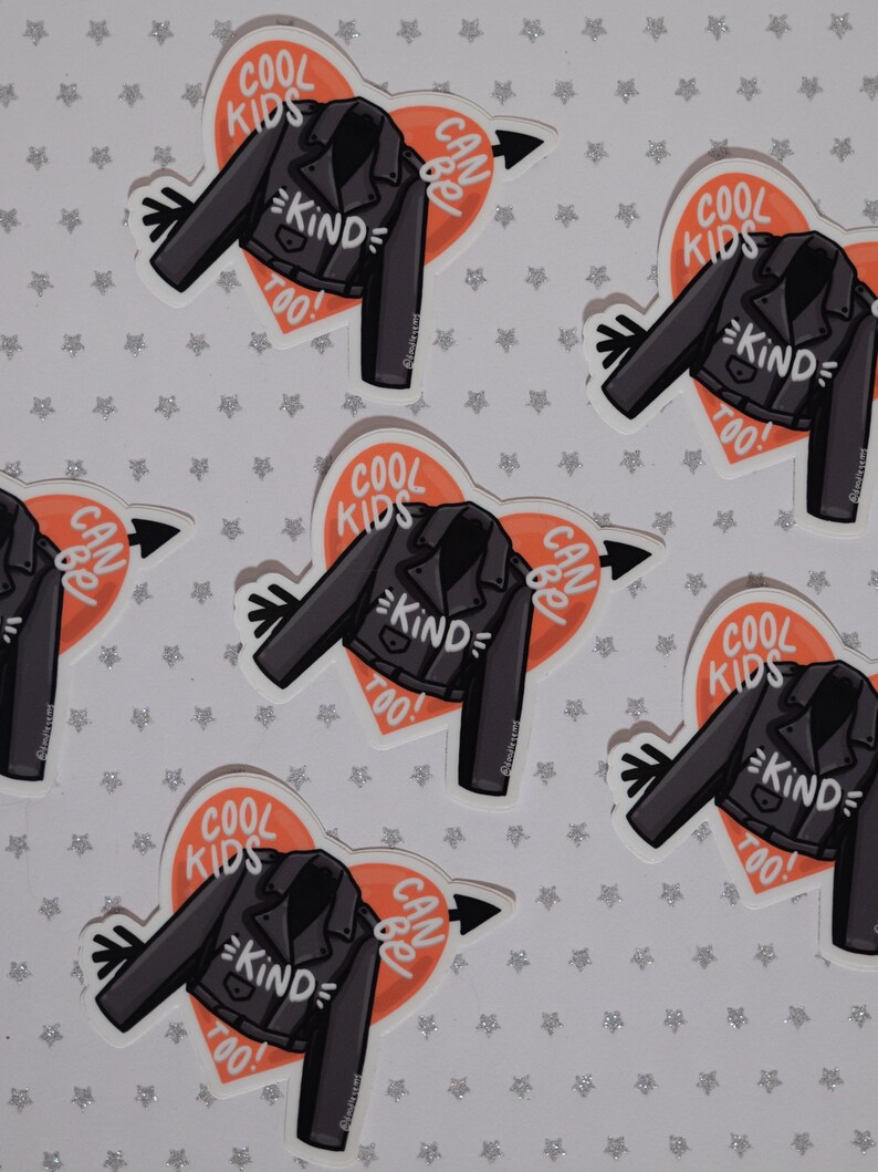 May include: Six stickers with a heart-shaped design featuring a black leather jacket with the text "Cool Kids Can Be Kind Too!" in white lettering. The heart is orange and has a white arrow pointing to the right.