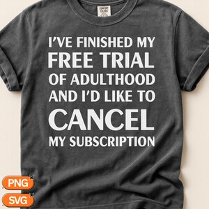 Pode incluir: Uma t-shirt de manga curta cinzento-escura com texto branco que diz: I'VE FINISHED MY FREE TRIAL OF ADULTHOOD AND I'D LIKE TO CANCEL MY SUBSCRIPTION. A t-shirt apresenta um decote redondo e uma etiqueta da marca Comfort Colors no colarinho.