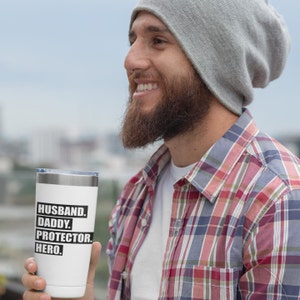 May include: White stainless steel tumbler with black text that reads "Husband. Daddy. Protector. Hero."