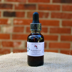 May include: A dark amber glass bottle with a black dropper top. The label reads "Red Cardinal Store" and "Marshmallow Leaf (Althaea officinalis)". The bottle contains a dark liquid, likely an herbal extract, and is 1 fluid ounce.