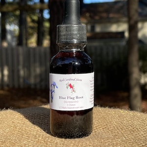 May include: A glass bottle with a dropper top filled with a dark liquid. The label reads "Red Cardinal Store" and "Blue Flag Root (Iris versicolor) 1 Ounce 1:2 Herb/menstruum ratio".