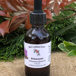 May include: A 2 ounce bottle of Rehmannia (Rehmannia glutinosa) tincture with a 1:2 herb/menstruum ratio. The bottle is brown glass with a black dropper lid. The label is white with red cardinal illustration and text.