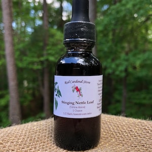 May include: A dark brown glass bottle with a dropper top, labeled "Red Cardinal Store Stinging Nettle Leaf (Urtica dioica) 1 Ounce 1:2 Herb/menstruum ratio".