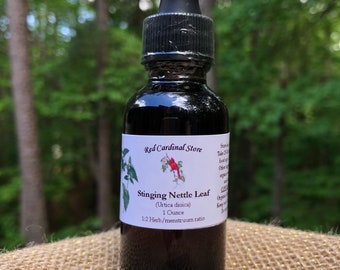 May include: A dark brown glass bottle with a dropper top, labeled "Red Cardinal Store Stinging Nettle Leaf (Urtica dioica) 1 Ounce 1:2 Herb/menstruum ratio".