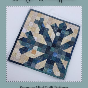 Peut inclure: Un modèle de courtepointe miniature en patchwork avec un motif de flocon de neige bleu et crème. La taille finie est de 13 pouces sur 13 pouces. La courtepointe est faite avec une variété de tissus et a une bordure bleue. La courtepointe est parfaite pour un débutant en courtepointe.