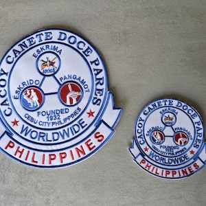 May include: A set of three ceramic mugs with a speckled, matte finish. The mugs are in shades of cream, light gray, and dark gray. Each mug has a simple, minimalist design and a rounded handle.