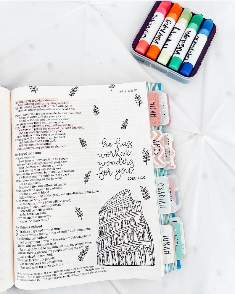 May include: A black and white illustration of a building with a quote from the Bible, "He has worked wonders for you." The quote is from Joel 2:26. The illustration is surrounded by colorful tabs with the names of different books of the Bible, including Micah, Amos, Obadiah, Jonah, and Joel.
