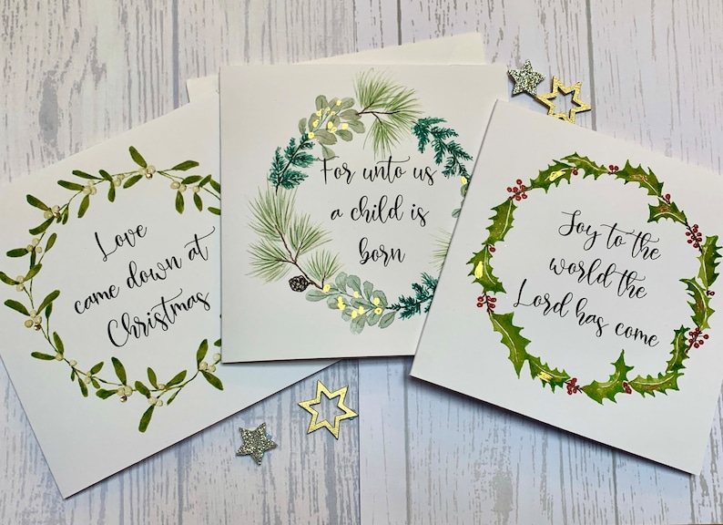 May include: Three Christmas cards with watercolor illustrations of wreaths and greenery. The cards feature the following text: "Love came down at Christmas", "For unto us a child is born", and "Joy to the world the Lord has come".