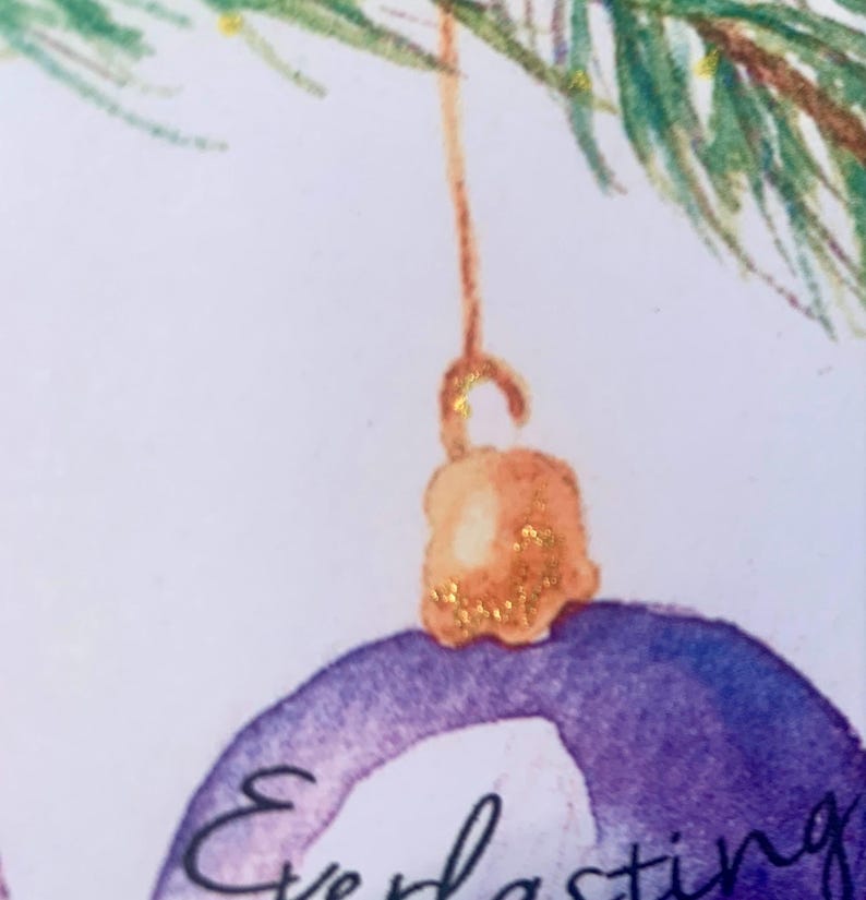 May include: A purple Christmas ornament with gold glitter hanging from a branch. The ornament has the word "Everlasting" written on it.