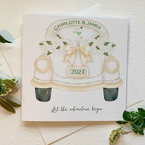 Carte de mariage personnalisée. Voiture « coccinelle » blanche portant l'inscription 2024 sur la plaque d'immatriculation. Prénom du couple agrémenté de strass