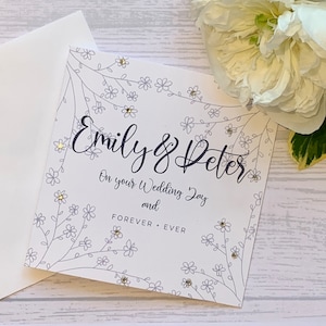 Carte de mariage personnalisée avec le nom du couple et Forever + Ever imprimés dessus. Fleurs délicates et petites dans un gris argenté.