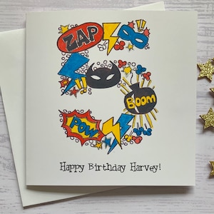 Carte personnalisée pour 5e anniversaire de super-héros. Illustration aquarelle de style dessin animé du chiffre 5 agrémentée de détails métalliques argentés.