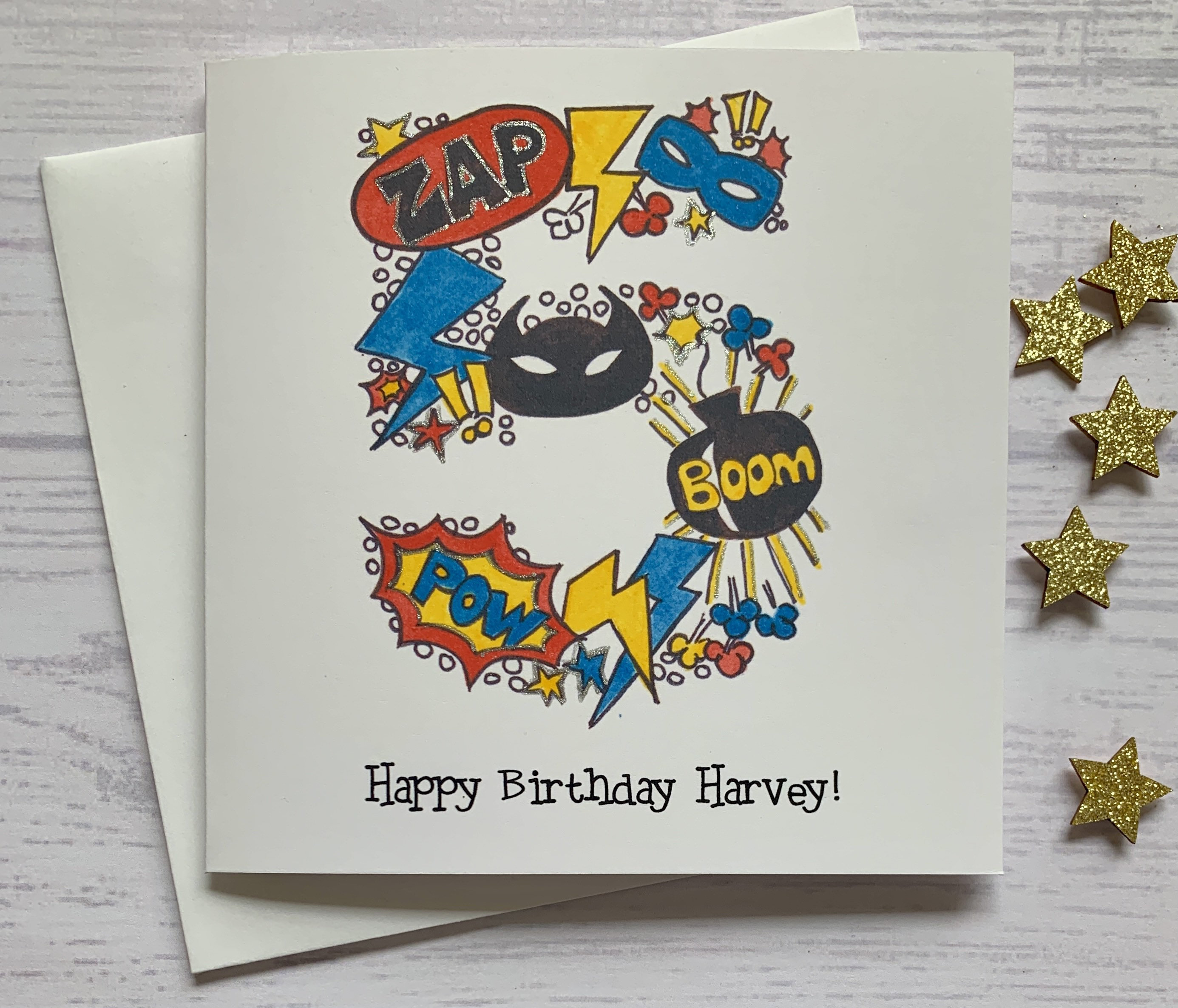 Superhero personalised 5th  birthday card . Cartoon style watercolour illustration of the number 5 embellished with silver metallic detail.