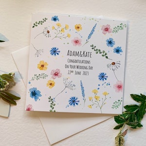 Carte de mariage personnalisée. Fleurs à l'aquarelle avec le nom du couple, « Félicitations pour votre mariage » et la date du mariage.