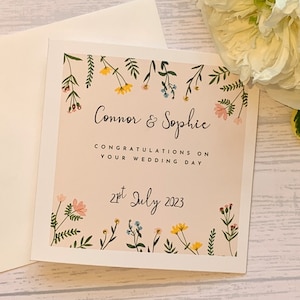 Carte de mariage personnalisée avec de belles petites fleurs et des feuilles agrémentées de petits strass.