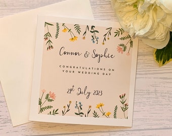 Carte de mariage personnalisée avec de belles petites fleurs et des feuilles agrémentées de petits strass.