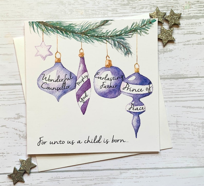 May include: A Christmas card with a watercolor illustration of purple and blue ornaments hanging from a pine branch. The ornaments have the words "Wonderful Counselor", "Mighty God", "Everlasting Father", and "Prince of Peace" written on them. The card also includes the text "For unto us a child is born..."