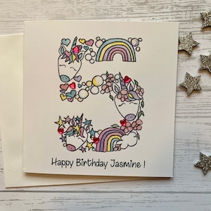 Unicorn personalised 5th  birthday card . Cartoon/doodle  style watercolour illustration of the number 5 embellished with heart gems..