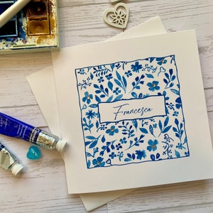 Named Birthday card . Striking blue and white watercolour border surrounding recipients name. Embellished with delicate gems.