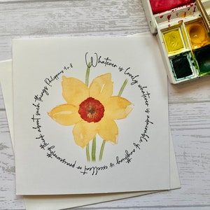 Może przedstawiać: Aquarela przedstawiająca żółty narcyz z czerwonym środkiem. Obraz otoczony jest kołem tekstu, które brzmi "Whatever is lovely whatever is admirable of anything is excellent" i "* praiseworthy think about such things Philippians 4:8".