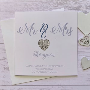 Carte de mariage personnalisée avec les mots « Mr & Mrs » en bleu poudré et bleu marine doux avec un cœur en strass. Le nom et la date peuvent également être ajoutés.