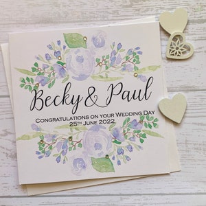 Carte de mariage personnalisée avec des fleurs lilas pâles et des strass délicats. Félicitations. Le jour de votre mariage